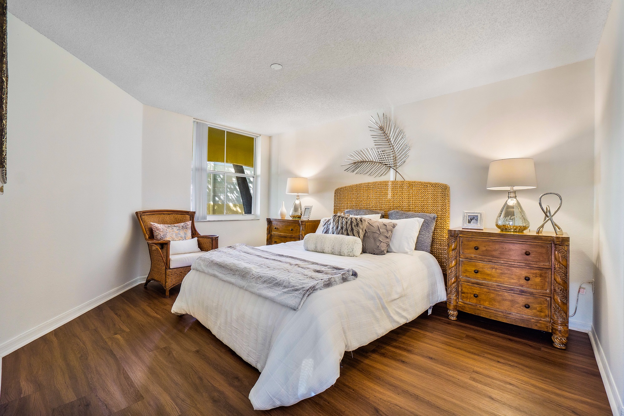 A bedroom with a bed, nightstand, and lamp.
